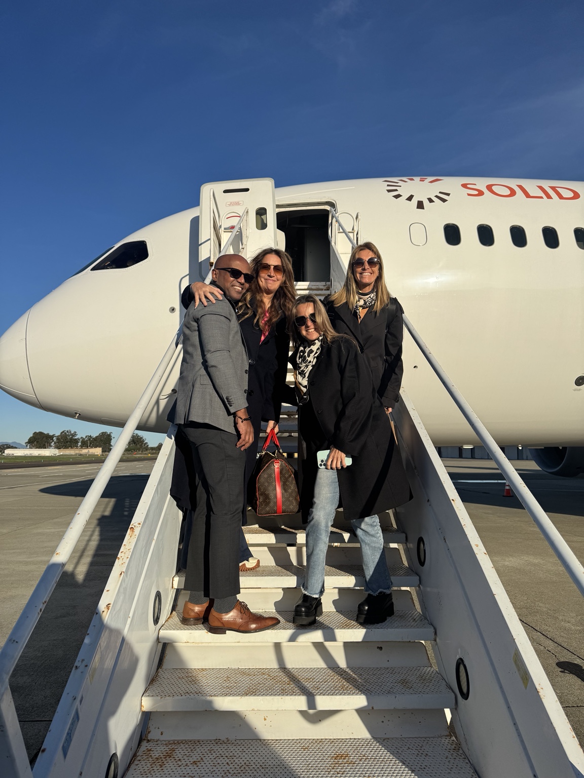 Chauffeur assisting guests beside a private aircraft