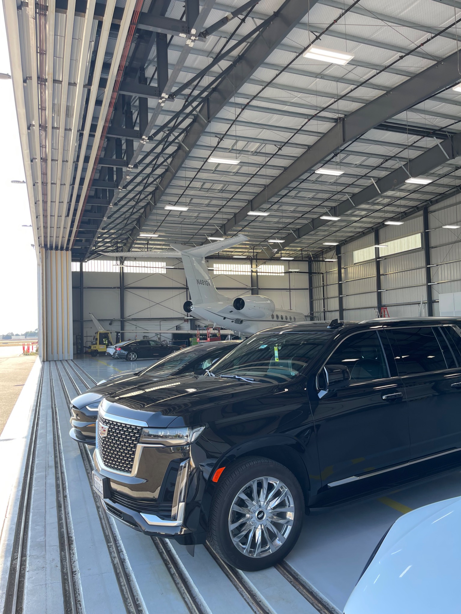 Black Cadillac Escalade positioned inside a private aviation hangar